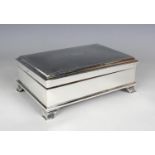 A George V silver rectangular trinket box with engine turned hinged lid, on bracket feet, with