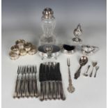 An Edwardian silver three-piece condiment set of oval shape, embossed with foliate scrollwork and