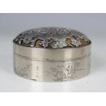 A Japanese silver circular box and cover, the domed cover cast and pierced with chrysanthemums