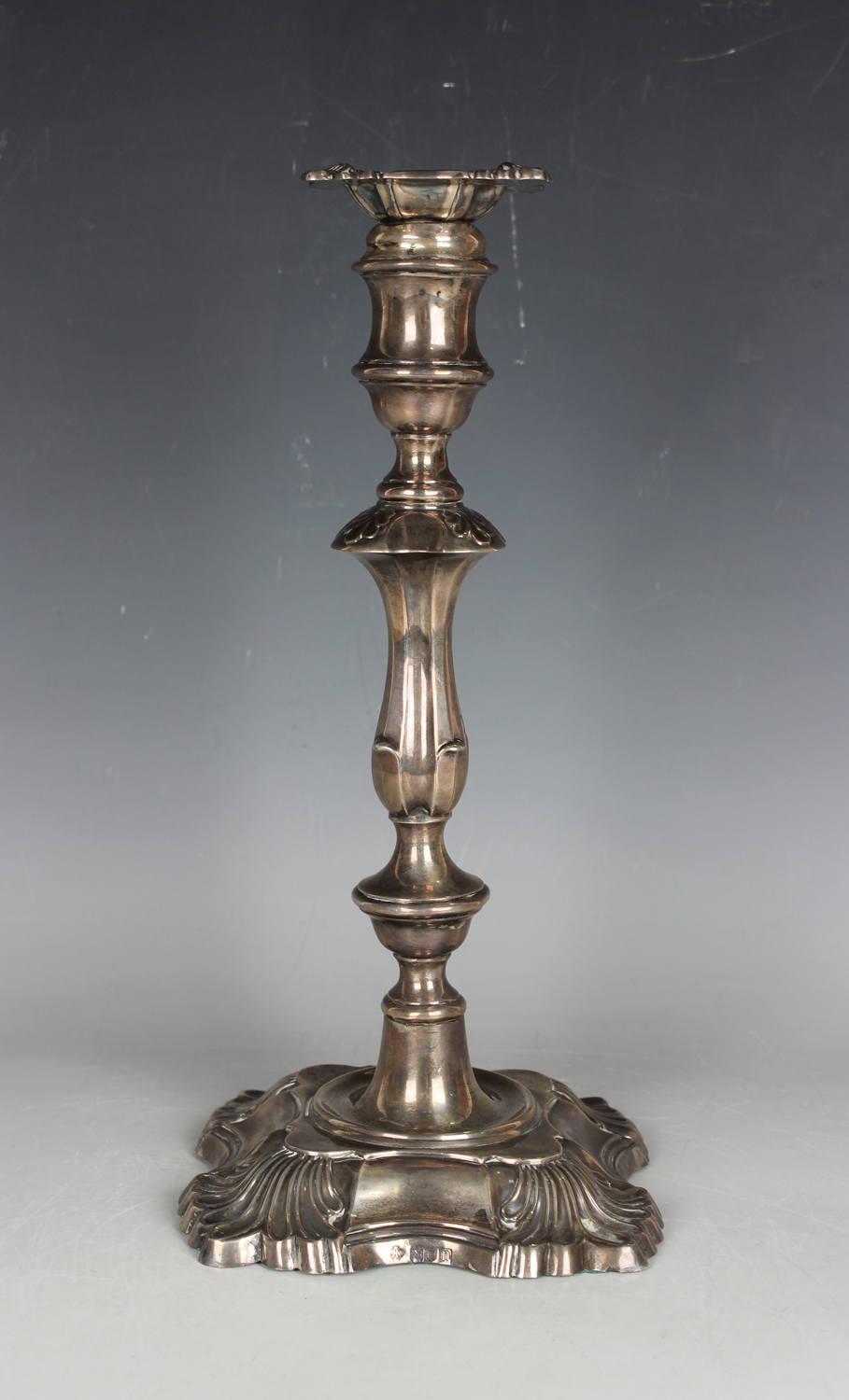 An Edwardian silver candlestick of baluster form with stylized scallop shell decoration, on a
