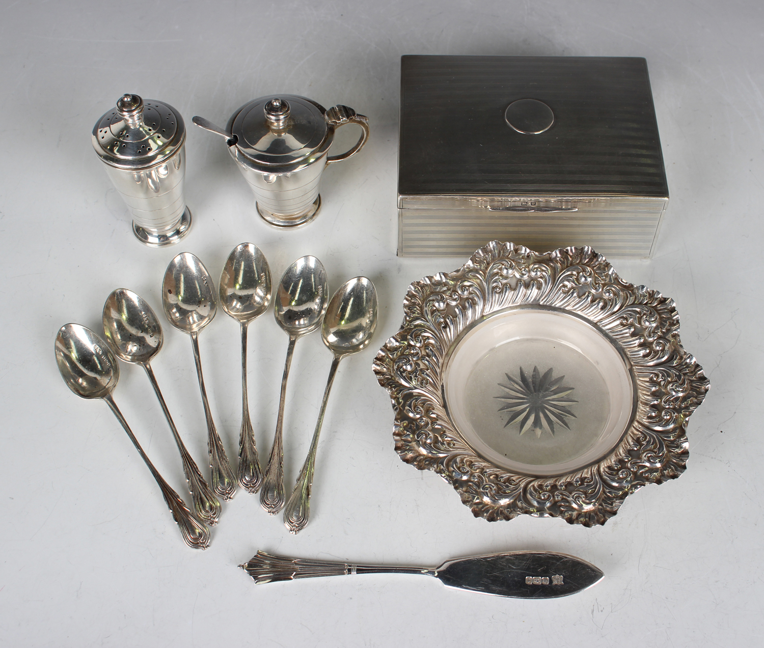 A late Victorian silver circular petal rimmed butter dish, decorated in relief with foliate scrolls,