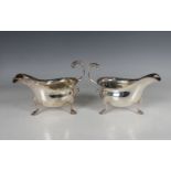 A pair of Edwardian silver sauceboats, each with a foliate capped flying scroll handle, on scroll