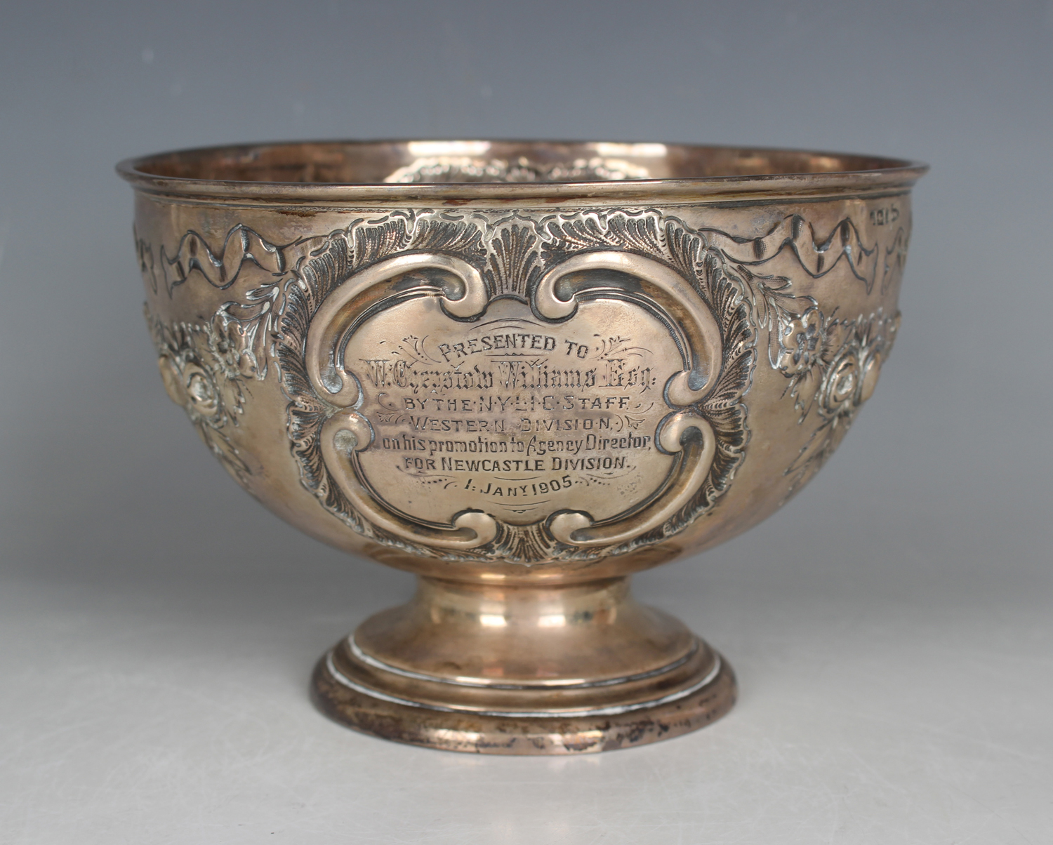 An Edwardian silver circular rose bowl, embossed with floral and ribbon garlands and opposing 'C'