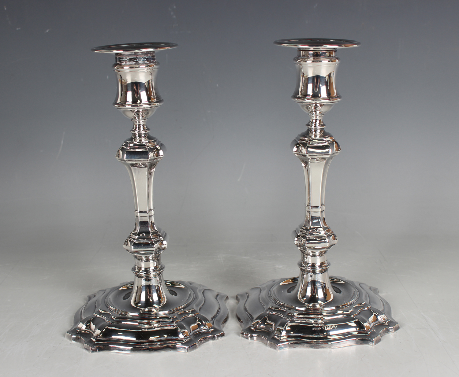 A pair of Elizabeth II silver candlesticks, each with a detachable nozzle above an urn shaped