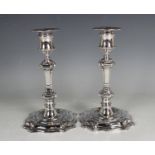 A pair of Elizabeth II silver candlesticks, each with a detachable nozzle above an urn shaped