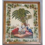 An early 20th century woolwork panel depicting figures beneath a palm tree, 63cm x 52cm, framed,