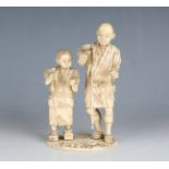 A late 19th century Japanese carved ivory sectional okimono figure group of a father and son, on