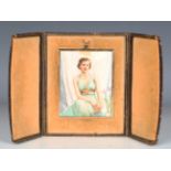 An early 20th century watercolour portrait miniature on ivory depicting a young lady seated beside