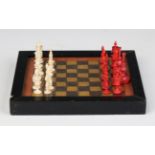 A late 19th/early 20th century turned bone and red stained miniature chess set, height of king