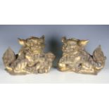 A pair of 20th century South-east Asian gilt metal models of temple dogs, length 33cm.Buyer’s