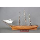 A late 20th century wooden scale model of a naval frigate with three tall masts and folded sails, on