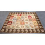 A large early 20th century woolwork carpet or wall hanging, worked with overall polychrome squares