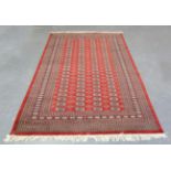 A Pakistan bokhara rug, late 20th century, the red field with overall columns of guls, within a