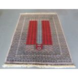 A Pakistan ensi style prayer rug, late 20th century, the claret mihrab with overall rows of stylized