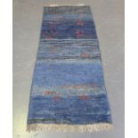 A South Persian gabbeh runner, late 20th century, the shaded blue field sparsely decorated with