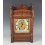 A late 19th century oak mantel clock with eight day movement striking on a gong, the backplate