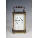 An early 20th century French brass cased carriage alarm clock with eight day movement striking on