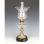 A late Victorian clear cut glass and pressed brass table oil lamp with a clear glass shade and black