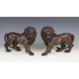 A pair of late 20th century brown patinated cast bronze models of lions, height 23cm, length 32cm.