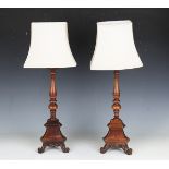 A pair of early 20th century Carolean Revival walnut table lamps with triform bases, height 42cm.