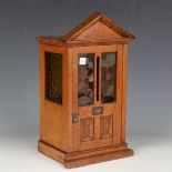 An Edwardian oak table-top postbox, modelled as a front door and porch with shaped pediment and