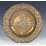 A 19th century brass alms dish, embossed to the centre with a Gothic cross within a wide border