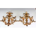 A set of three 20th century gilt metal two-branch wall sconces, each of foliate scroll design,