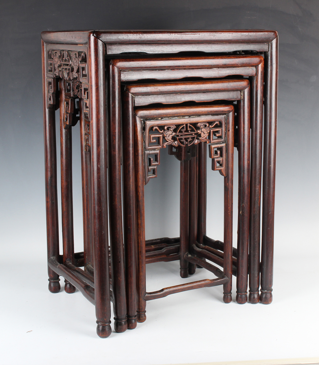 A Chinese hardwood quartetto nest of occasional tables, late Qing dynasty, each rectangular panelled