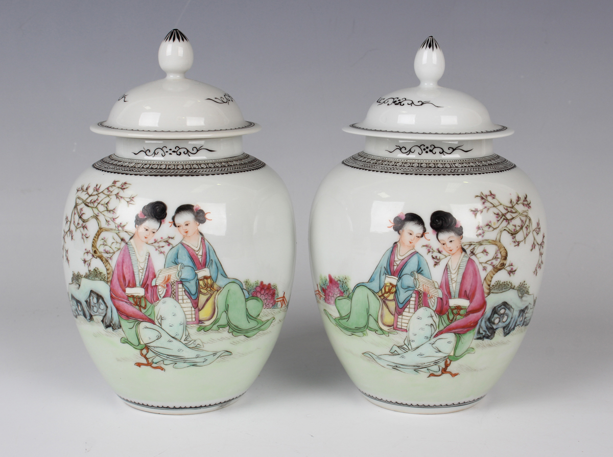 A pair of Chinese famille rose porcelain jars and covers, 20th century, each ovoid body painted with