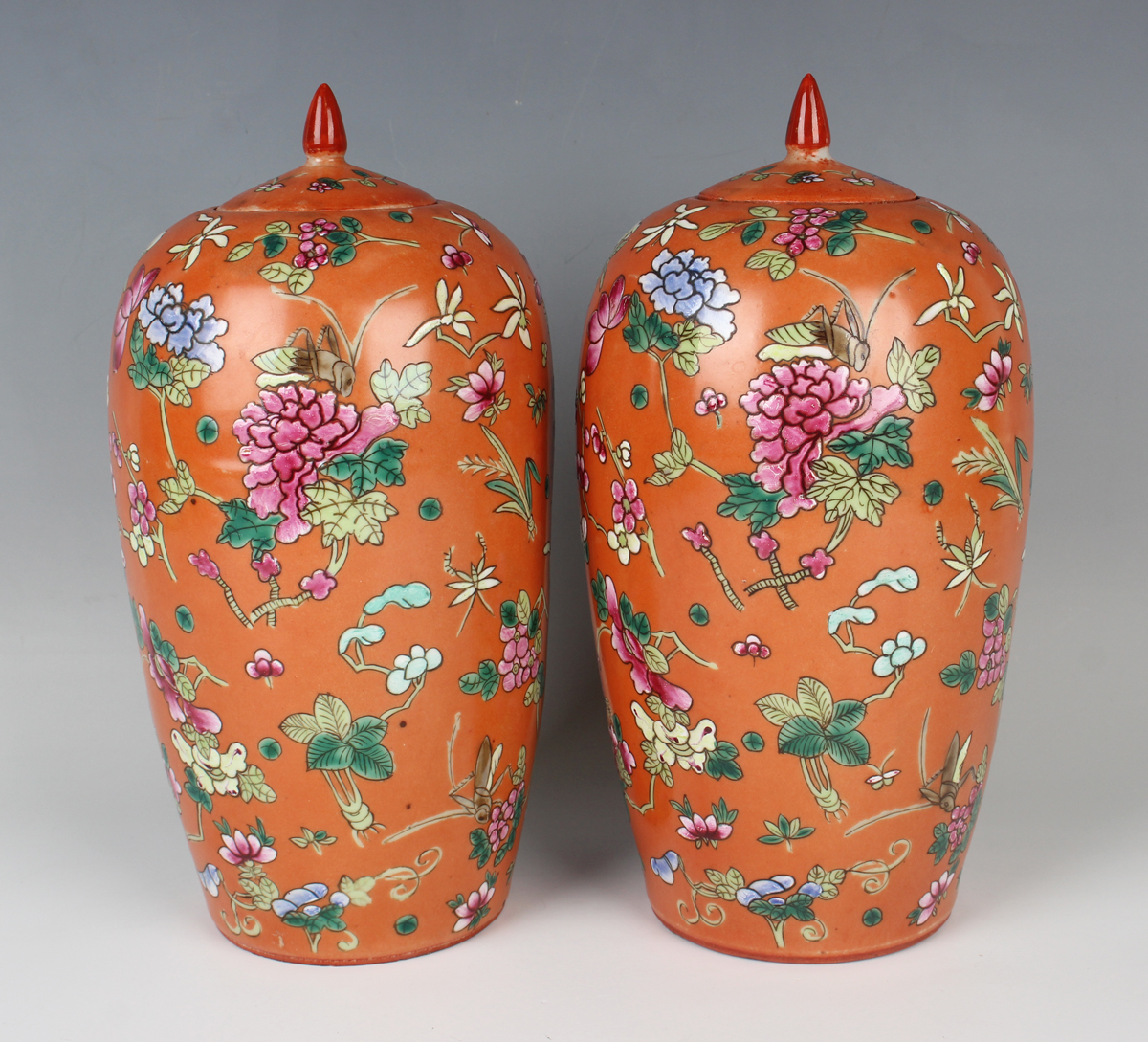 A pair of Chinese famille rose coral ground porcelain jars and covers, early 20th century, each of