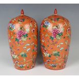 A pair of Chinese famille rose coral ground porcelain jars and covers, early 20th century, each of