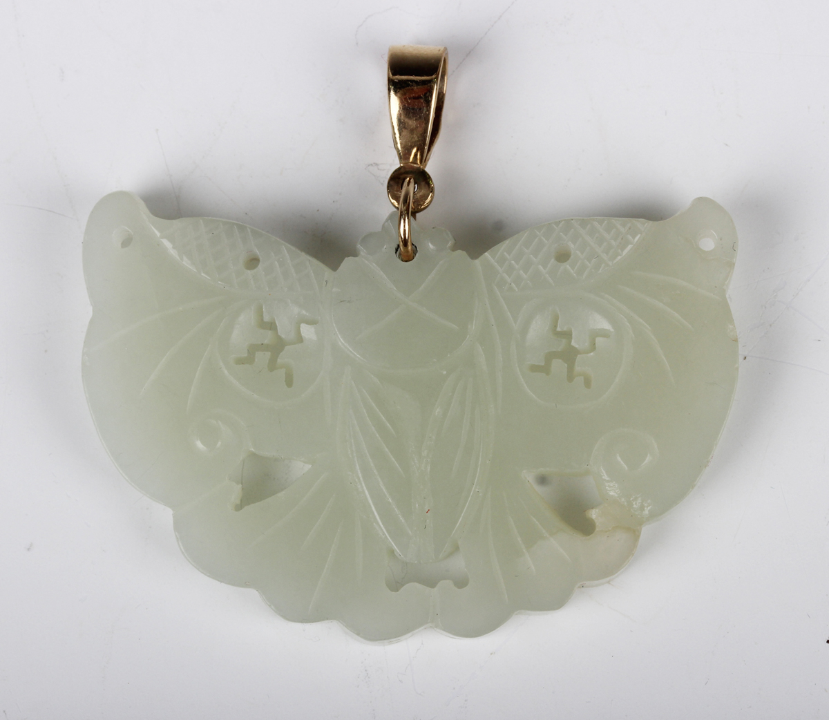 A Chinese pale celadon jade pendant, probably 20th century, carved and pierced in the form of a
