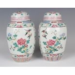 A pair of Chinese famille rose porcelain jars and domed covers, late Qing dynasty, each elongated