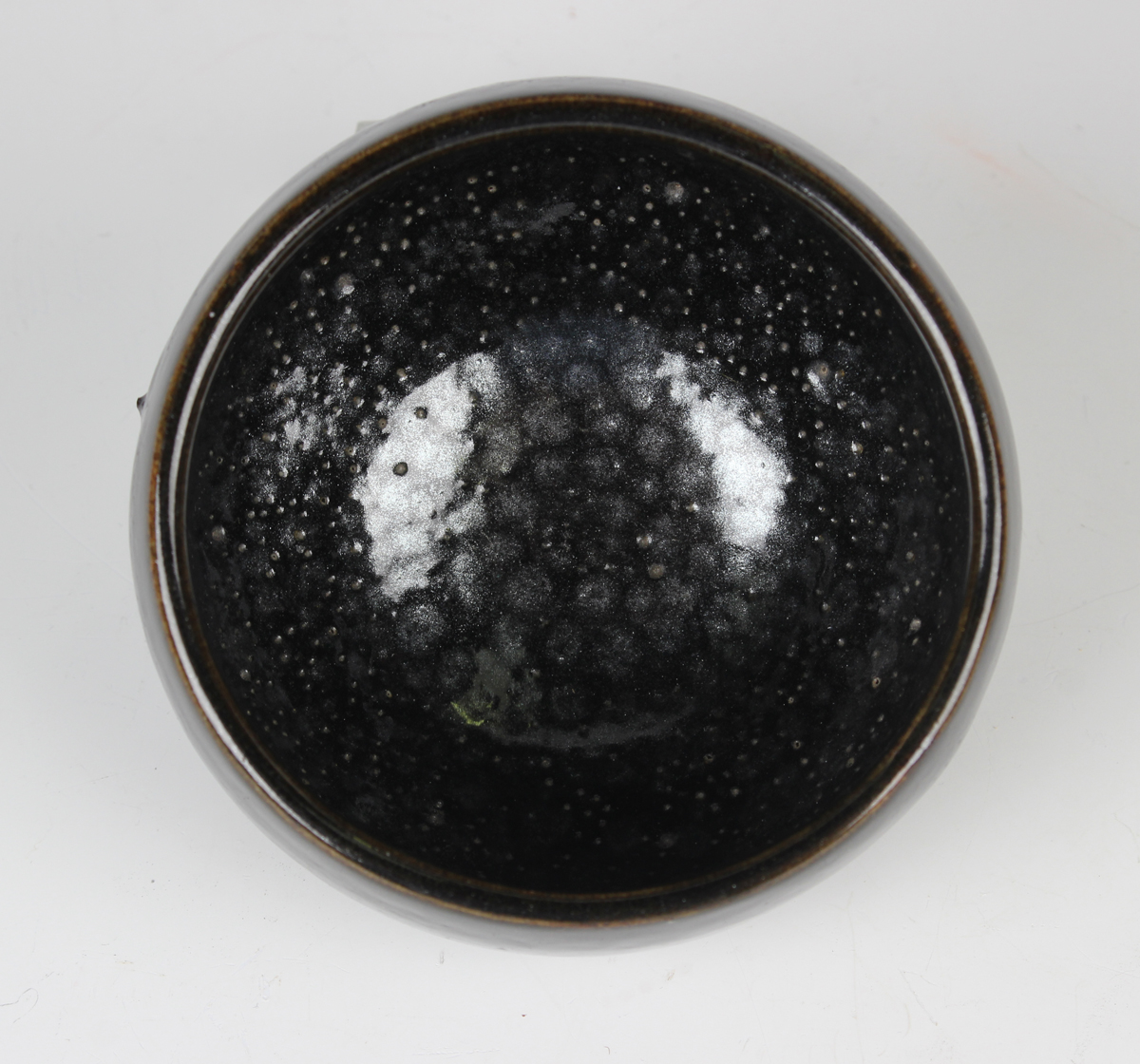 A Chinese dark brown glazed stoneware bowl, Song dynasty style but later, the interior with 'oil-