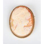 A 9ct gold mounted oval shell cameo brooch, carved as a portrait of a lady with a floral spray,