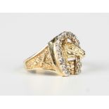 A gold and diamond ring, designed as a horse's head within a diamond set horseshoe shaped