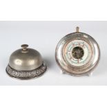 An Edwardian silver mounted circular desk bell, the base embossed with flowers and foliate