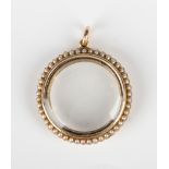 A gold and seed pearl circular pendant locket, glazed to the back and front, with a surround of seed