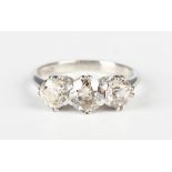 A platinum and diamond three stone ring, claw set with a row of circular cut diamonds, Sheffield