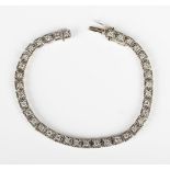 A white gold and diamond bracelet, mounted with a row of circular cut diamonds in square shaped