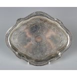 A Victorian silver teapot stand of lobed oval form with engraved decoration within a beaded rim,