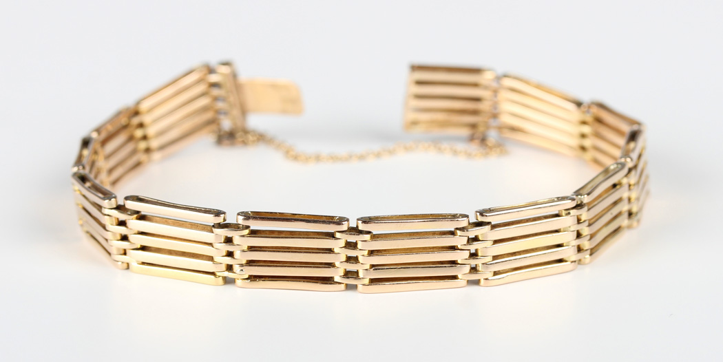 A gold bar and oval link gate bracelet on a snap clasp, detailed '15', weight 17g, length 17.8cm.