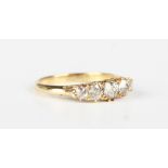 A gold and diamond five stone ring, mounted with a row of cushion cut diamonds graduating in size to