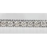 A 9ct white gold and diamond line bracelet, mounted with a row of circular cut diamonds, on a snap