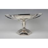 A George V silver tazza, the hexagonal bowl flanked by outswept handles terminating in leaves, on