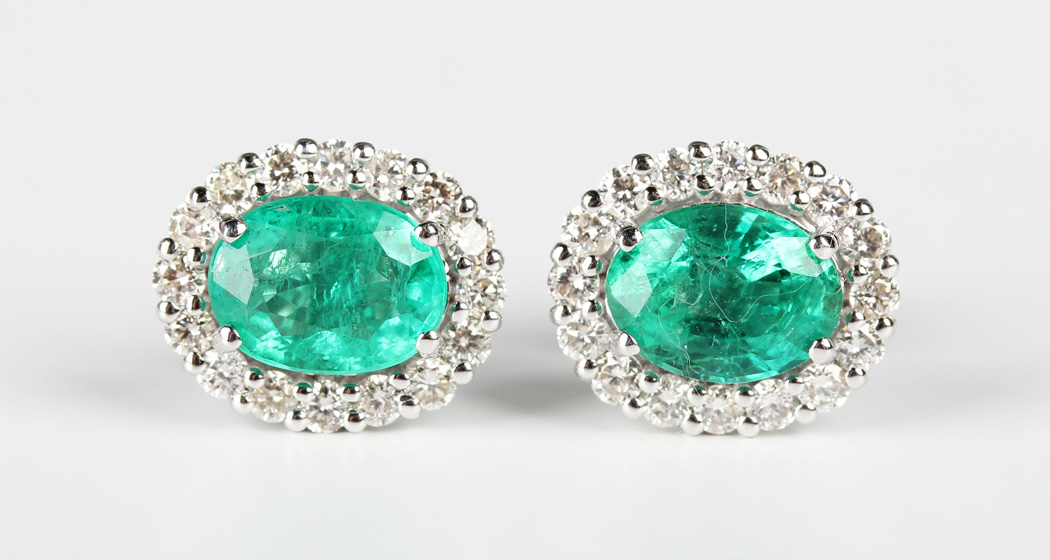 A pair of white gold, emerald and diamond oval cluster earstuds, each claw set with the oval cut