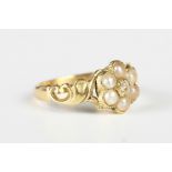 A Victorian gold, diamond and seed pearl cluster ring in a flowerhead shaped design with scroll