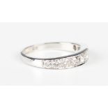 A white gold and diamond nine stone half-hoop eternity ring, mounted with a graduated row of