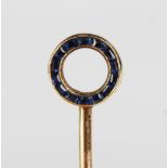 A gold, diamond and sapphire stickpin, the circular finial mounted with small cushion cut diamonds