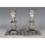 A pair of Victorian Classical Revival silver candlesticks, each with a beaded detachable nozzle